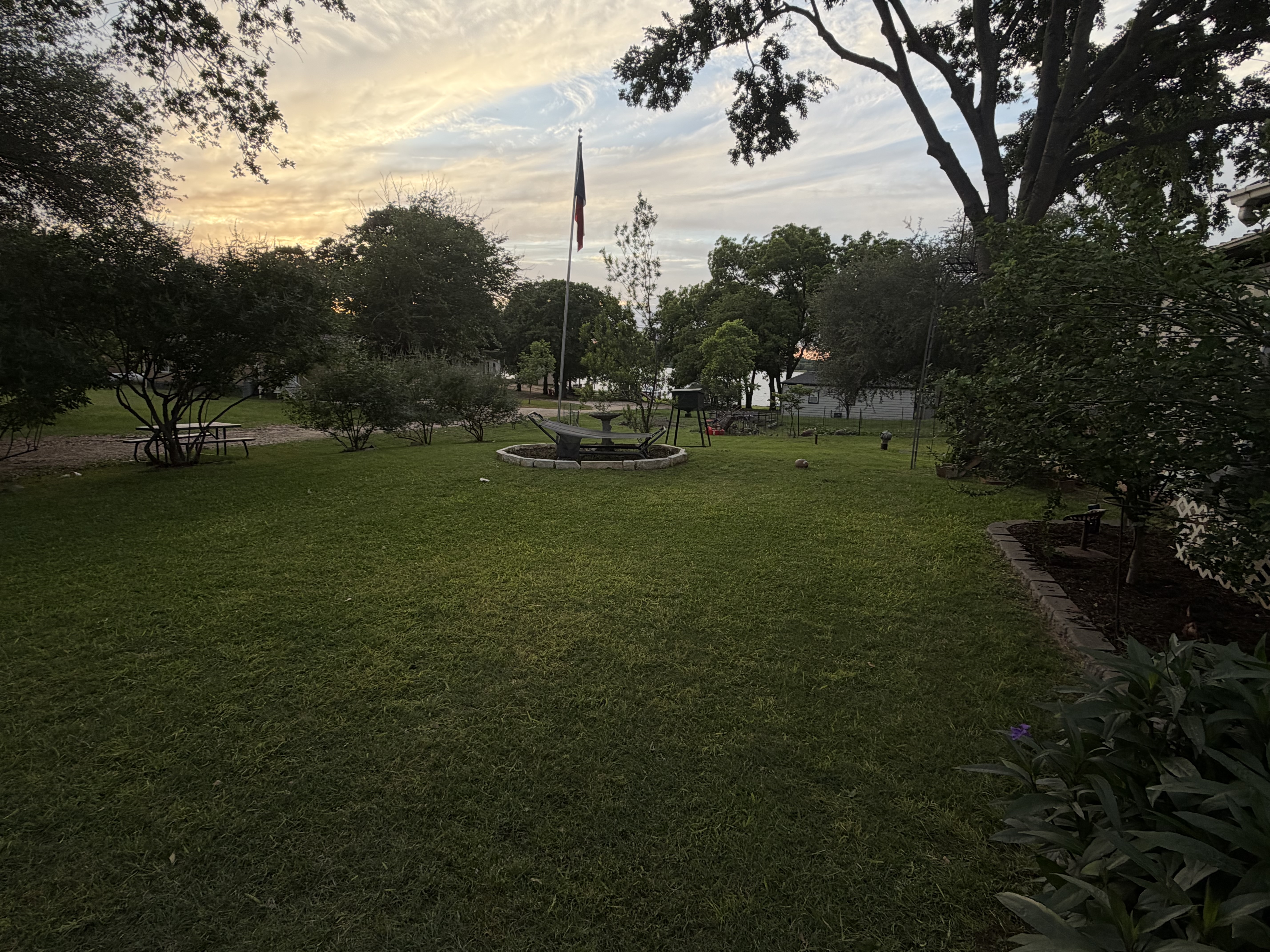 Beautiful landscaped lawn with Texas flag and fountain at sunset